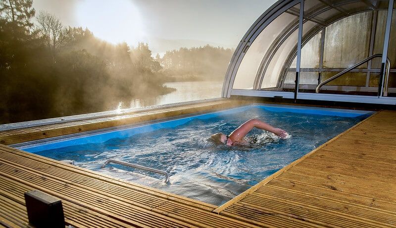 picture of a woman swims in an Endless Pools Performance model with a telescopic pool enclosure