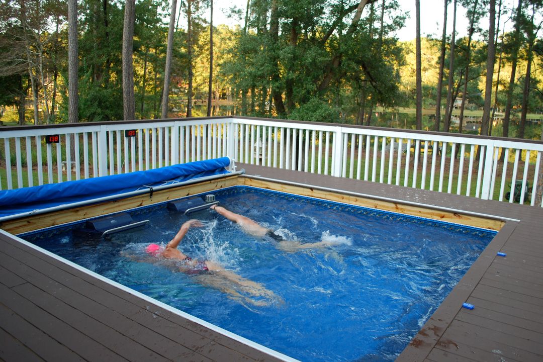 A picture of two people swimming side by side in a pool, each against their own endless current.