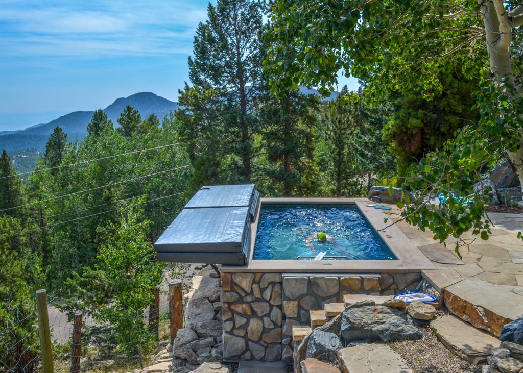 picture of Endless Pools Original pool in a sloped backyard with stone skirting