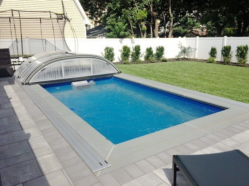 picture of fully in-ground Endless Pools Custom Series model under a low retractable pool enclosure