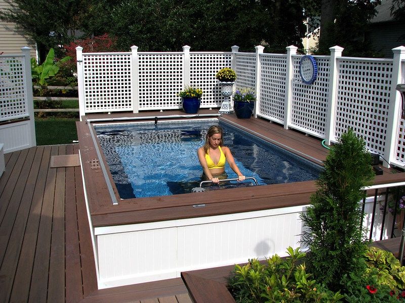 picture of a young woman uses the Endless Pools Underwater Treadmill on her pool deck